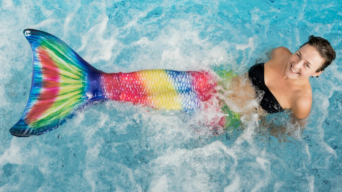 Mořská panna s barevným ocasem pózuje pod vodou